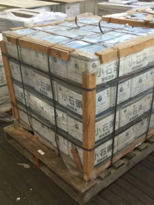 Stack of boxes on a pallet with wooden straps, indoor setting