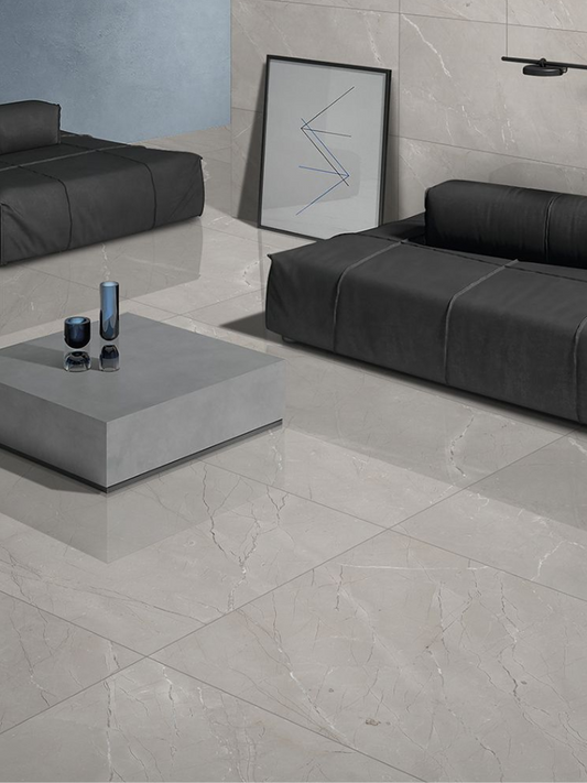 Modern living room with gray tiles, black sofa, and abstract art.