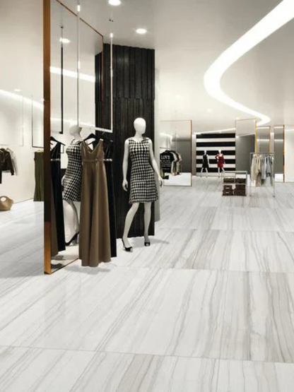 Modern clothing store interior with mannequins wearing dresses.