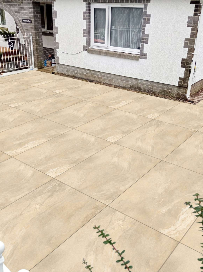 Beige tiles on a patio area in front of a house.
