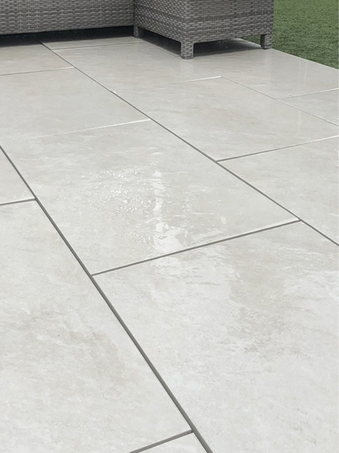 Gray patio tiles on a patio with outdoor furniture in the background