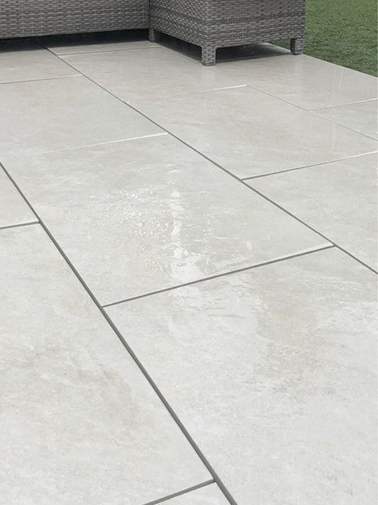 Gray patio tiles on a patio with outdoor furniture in the background
