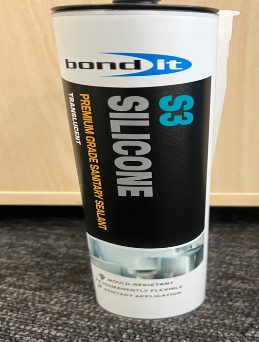A tube of Bond It S3 Silicone Premium Grade Sanitary Sealant, featuring a white and black label with blue and orange text, standing on a gray carpet in front of a light wood panel wall.